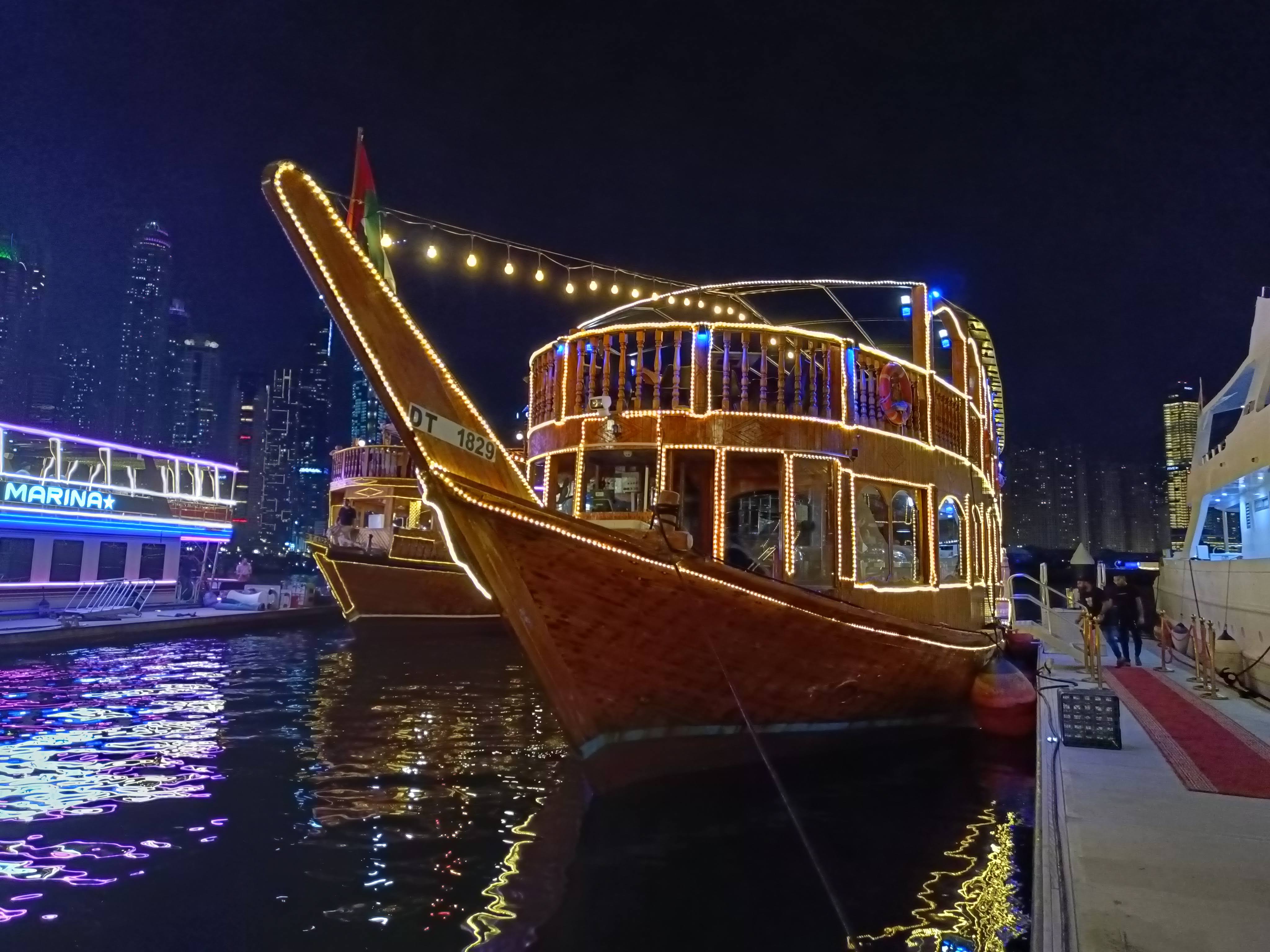 Dhow Cruise night view of illuminated Dubai Marina skyscrapers from the water
