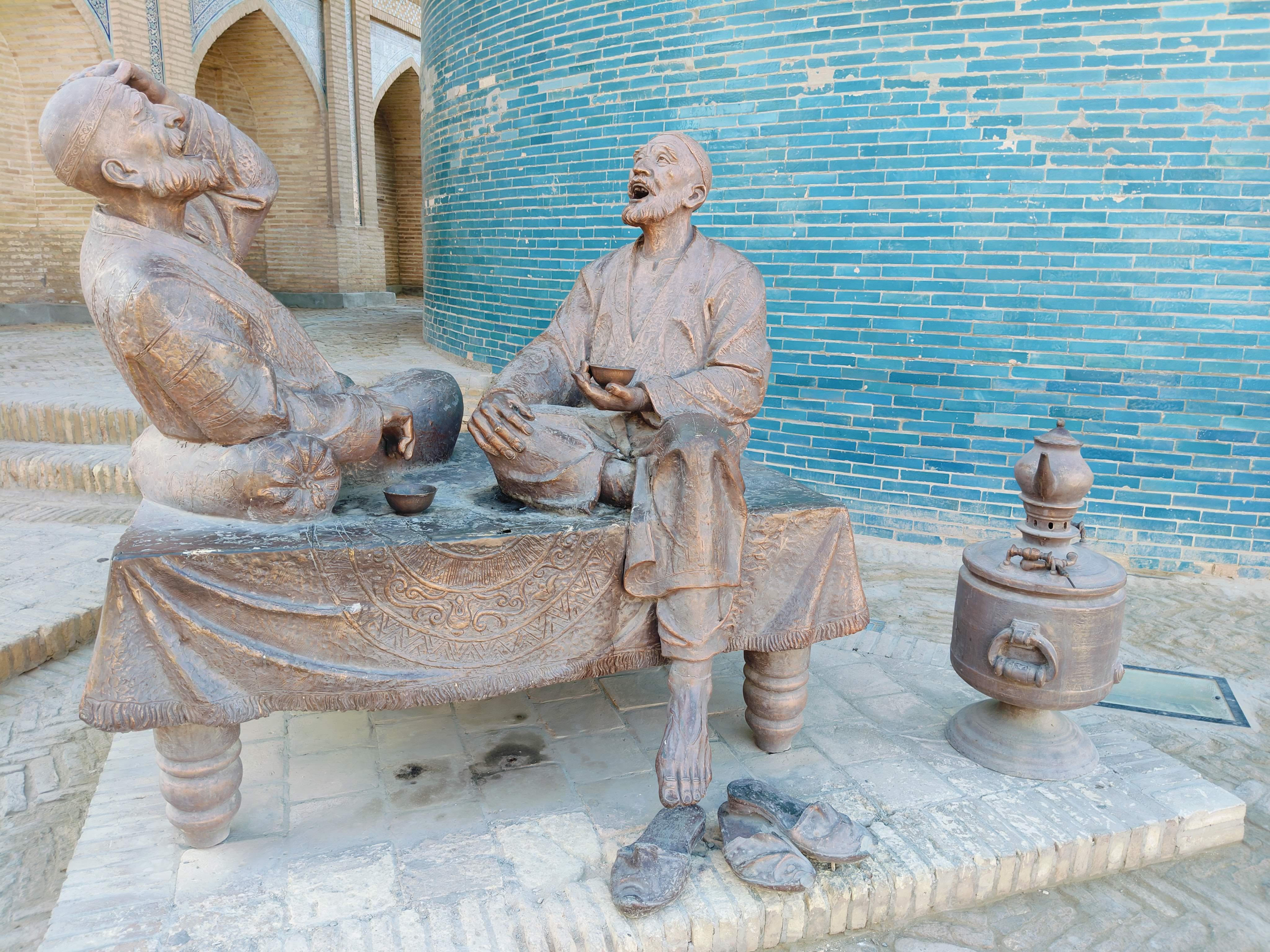 Traditional Uzbek tea culture - elderly local men enjoying tea in Khiva's historic district, authentic cultural scene showcasing Central Asian social customs and hospitality