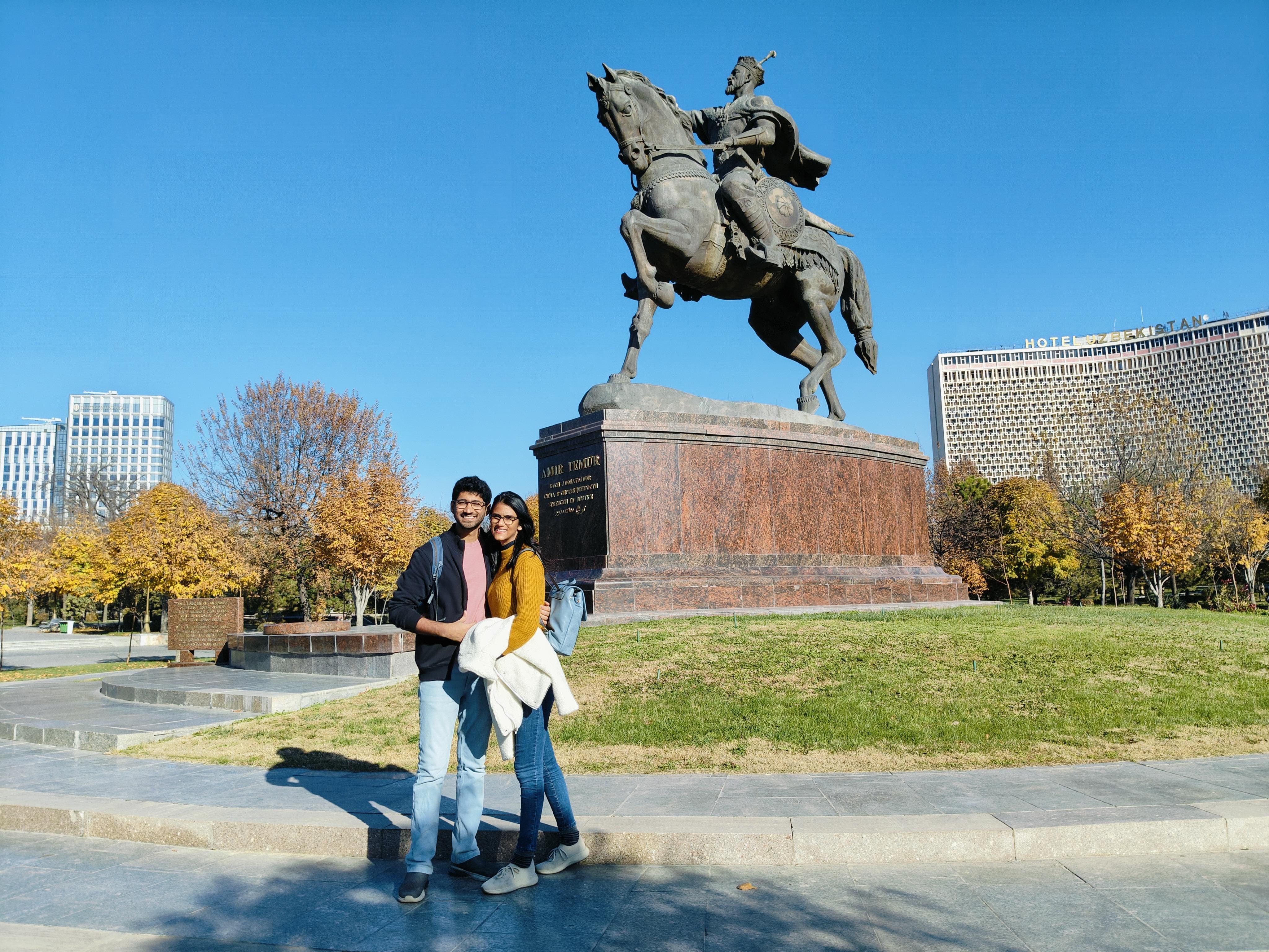 Visitors posing by iconic Amir Timur equestrian statue in Tashkent - central landmark honoring Uzbekistan's national hero and 14th-century conqueror in the city's main square