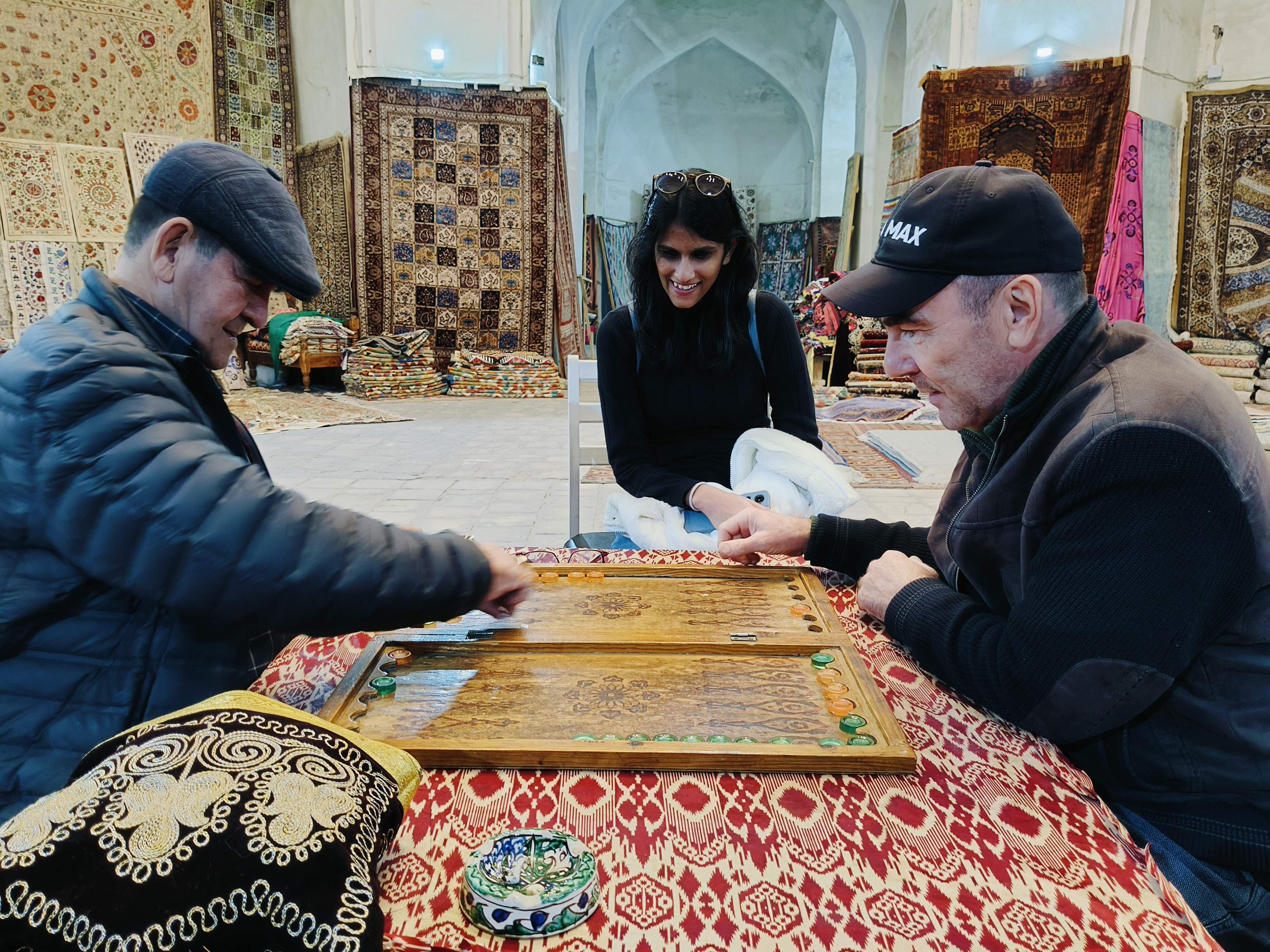 Elderly Uzbek men playing traditional backgammon in Bukhara - authentic cultural scene common throughout Uzbekistan's historic cities